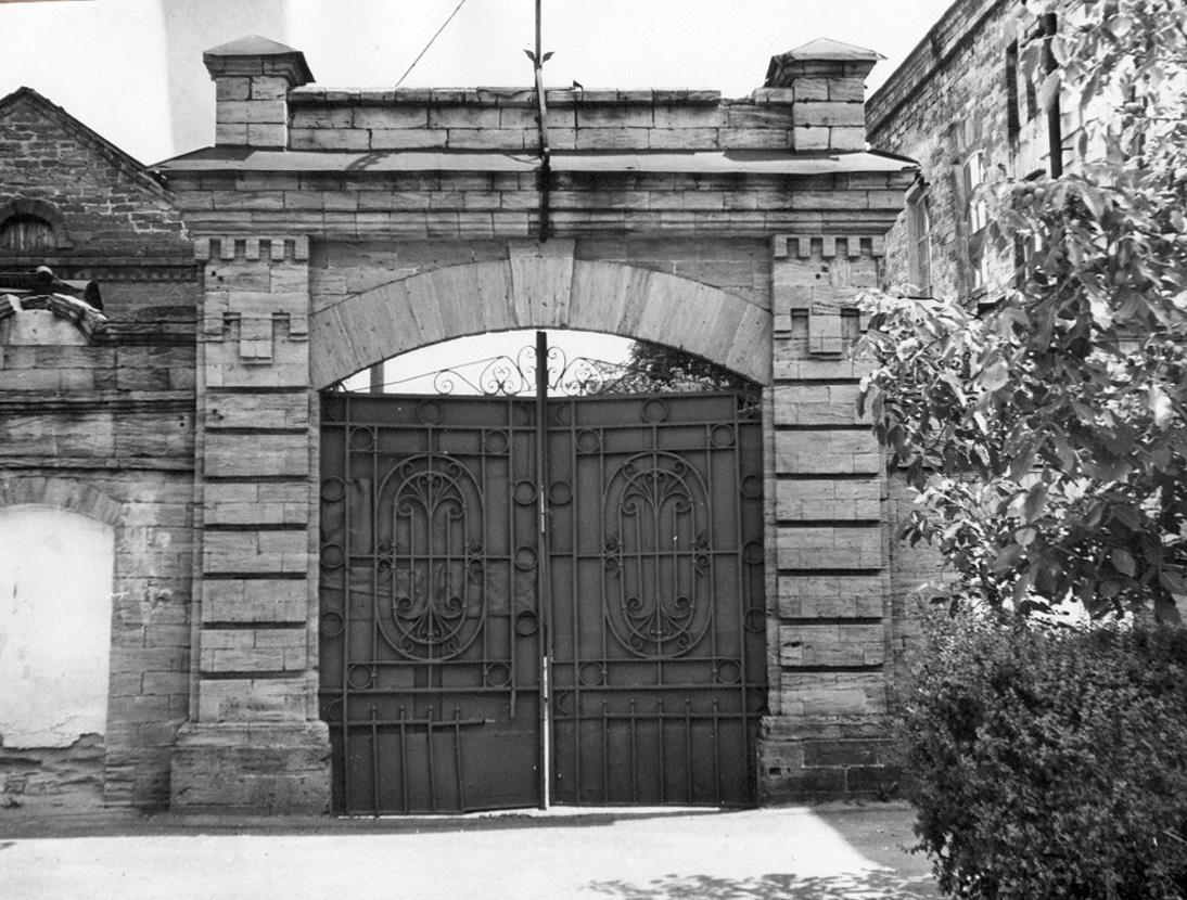 фрагмент стены завода с въездными воротами